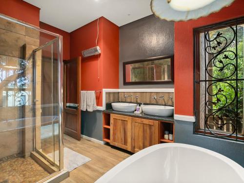 baño con 2 lavabos y paredes rojas en 295 on Ingwenya, en Dullstroom