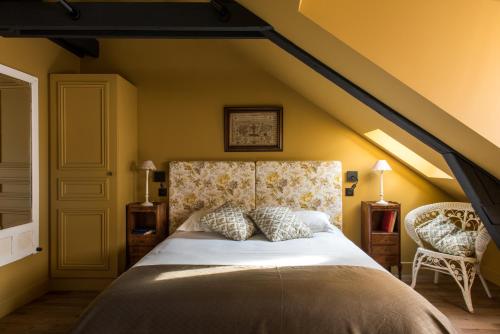 um quarto com uma cama grande e uma parede amarela em La Villa Augustine em Dieppe