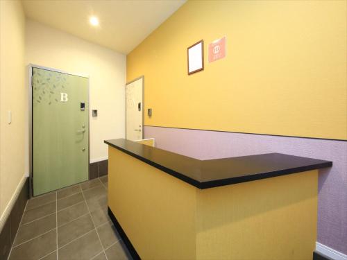 a waiting room with a yellow and purple wall at COTO Tokyo Shibuya 2 in Tokyo