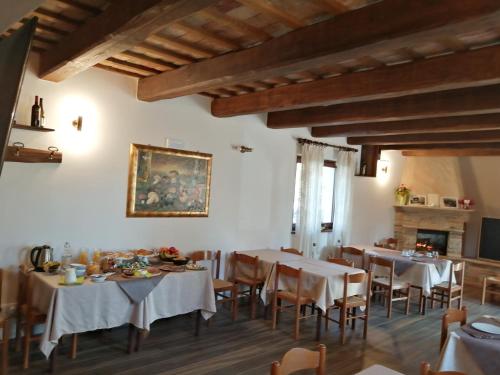 a dining room with tables and chairs and a fireplace at Agriturismo NONNU LUI` in Amandola