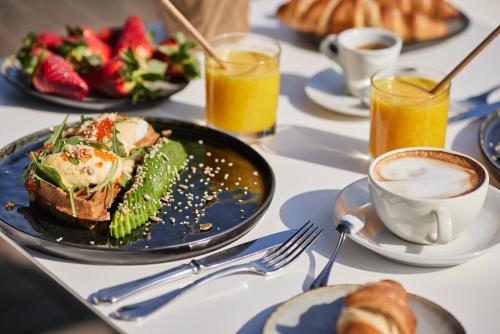 a table with a plate of food and a cup of coffee at Apvalaus Stalo Klubas Gastro & SPA Hotel in Trakai