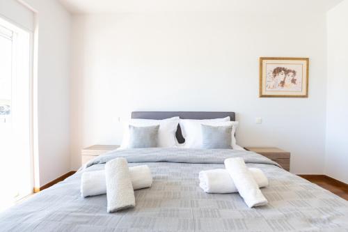a bedroom with a large bed with white pillows at Athenian Riviera Maisonette, Varkiza, 7min walk from Beach Park in Vari