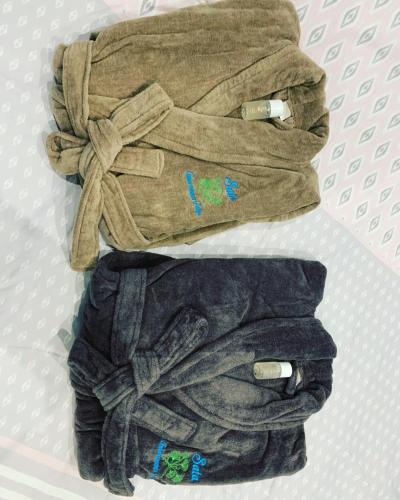 une pile de vêtements assis sur un lit dans l'établissement Appartement spa gingko, N1 Valenciennes, Wifi, Netflix, à Aulnoy