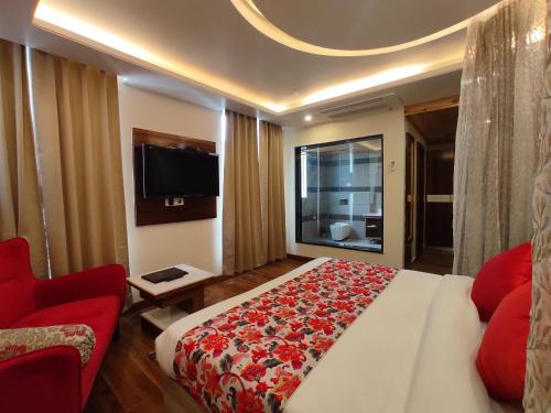 a bedroom with a large bed and a red couch at Abhilashi Residency & Spa - Centrally Heated & Air Cooled in Manāli