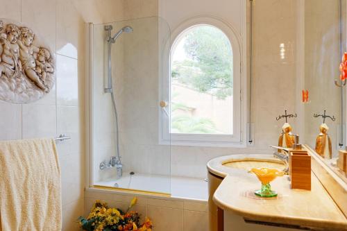 a bathroom with a sink and a shower and a window at Patio de los Gatos in Tamariu