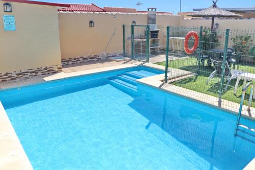 a swimming pool with a fence around it at Bungalow Curro Pareja 97 in Conil de la Frontera