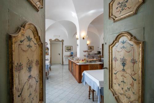 a room with two tables and a room with a kitchen at Hotel Casa Albertina in Positano