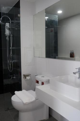 a bathroom with a toilet and a sink and a shower at Darin Chiangmai Hotel and Residence in Chiang Mai
