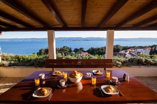 una mesa con comida y vistas al océano en Holiday Home Baki, en Bol