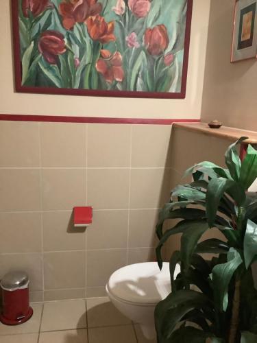 a bathroom with a toilet and a painting on the wall at Rosenhof in Görisried