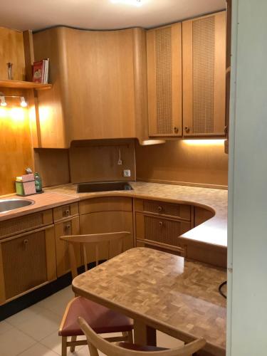 a kitchen with wooden cabinets and a table and chairs at Rosenhof in Görisried