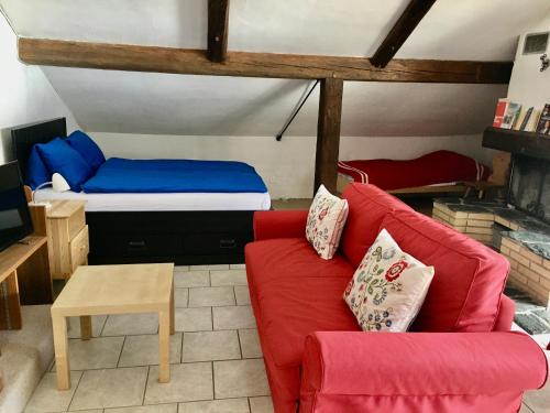 un soggiorno con divano rosso e letto di Jambo a Valchava