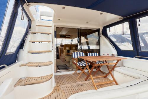 a table and chairs in the back of a boat at Mad Moment-Two Bedroom Luxury Motor Boat In Lymington in Lymington