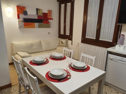 una mesa blanca con platos y platos en la cocina en 12 minuti da Venezia appartamento con parcheggio, en Marghera