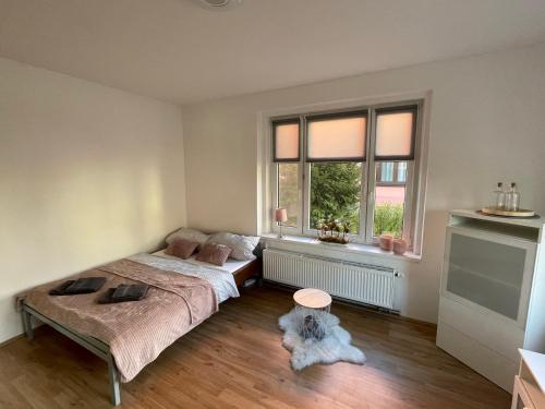 sypialnia z łóżkiem i pies siedzący na podłodze w obiekcie Apartmán Na Polabí w Mielniku