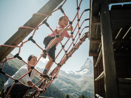 two children are riding on a roller coaster at Riffelalp Resort 2222m Ski-in & Ski-out in Zermatt