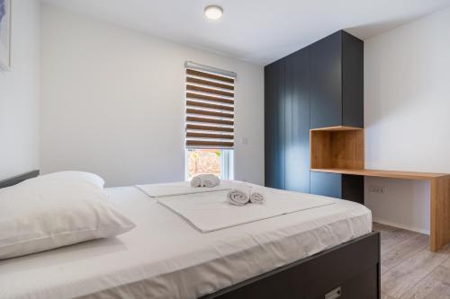 Un dormitorio con una gran cama blanca y una ventana en Blue Sorbeto, en Cres