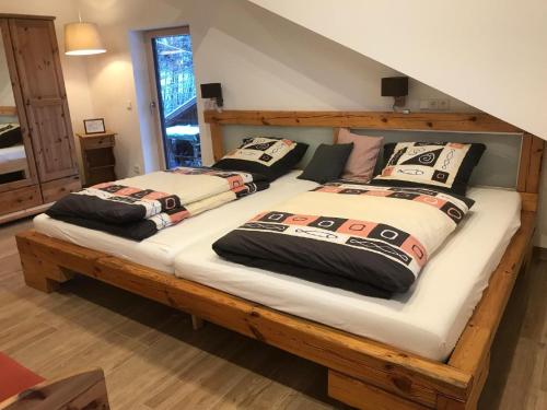 2 camas de madera con almohadas en una habitación en Ferienwohnung NaturZeit en Sankt Englmar