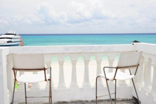 2 sillas sentadas en un balcón con vistas al océano en Casita Azul Oceanfront 1 bed condo PMS6, en Playa del Carmen
