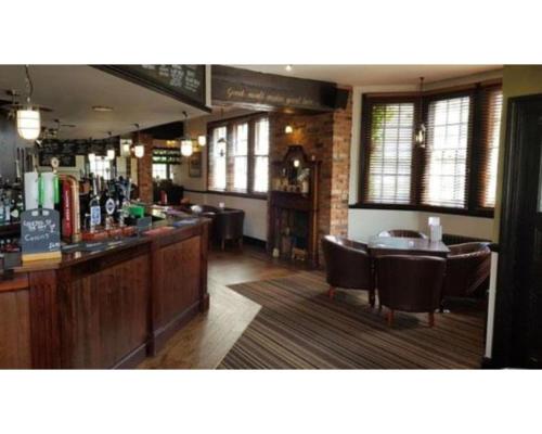 um bar num restaurante com cadeiras e uma mesa em The Red Lion Hotel em Chester-le-Street