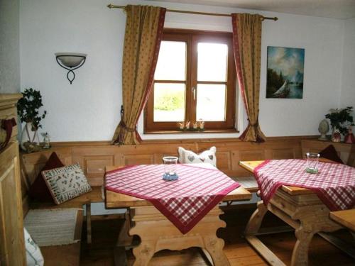een eetkamer met 2 tafels en een raam bij Pension Louise in Reit im Winkl