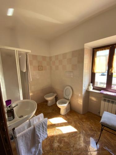 La salle de bains est pourvue de toilettes blanches et d'un lavabo. dans l'établissement Albergo Bar Ristorante Vecchio Mulino, à Bobbio