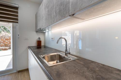 a kitchen with a stainless steel sink and a window at Apartment Blue Monstéra in Cres