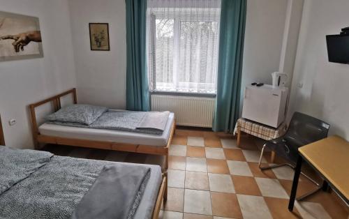 a small room with two beds and a window at Hotel Colibri in Zdzieszowice