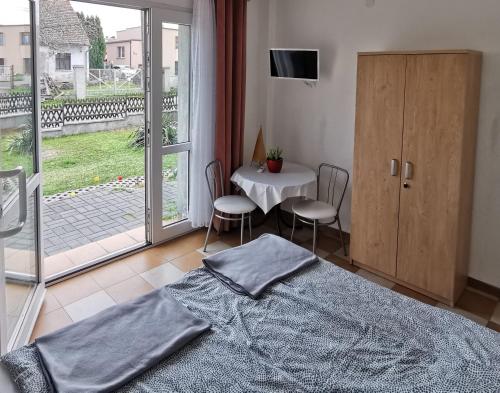 a bedroom with a bed and a table with chairs at Hotel Colibri in Zdzieszowice