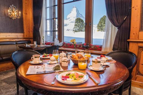 a dining room table with plates of food on it at Riffelalp Resort 2222m - Ski-in, Ski-out in Zermatt