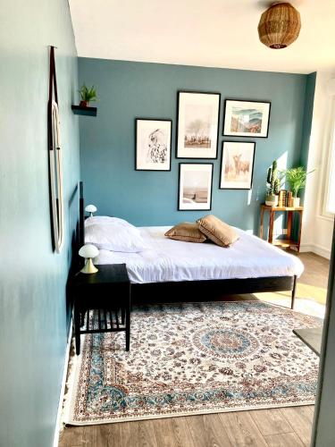 um quarto com uma cama e uma parede azul em Charmant appartement em Épinal