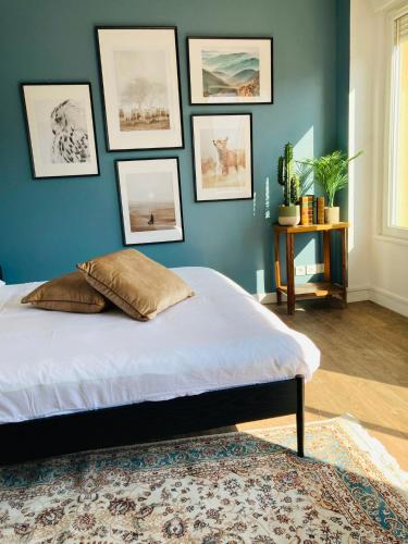 um quarto com uma cama com uma parede azul em Charmant appartement em Épinal