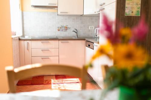 a kitchen with white cabinets and a sink at APARTMA JANJA in Bovec