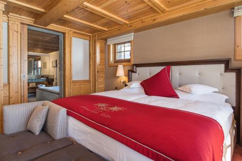 a bedroom with a large bed with a red blanket at Riffelalp Resort 2222m Ski-in & Ski-out in Zermatt