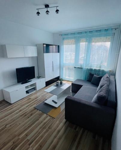 a living room with a couch and a tv at Elli apartament in Gdynia