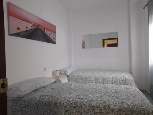 a bedroom with two beds and a picture on the wall at CASA INDEPENDIENTE EN NERVION JUNTO A PARADA DEL METRO in Seville