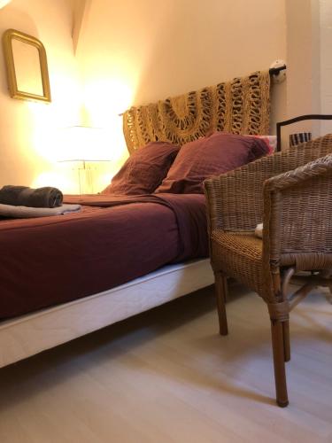 ドーヴィルにあるLe Petit Mornyのベッドルーム1室(ベッド1台、椅子、ランプ付)