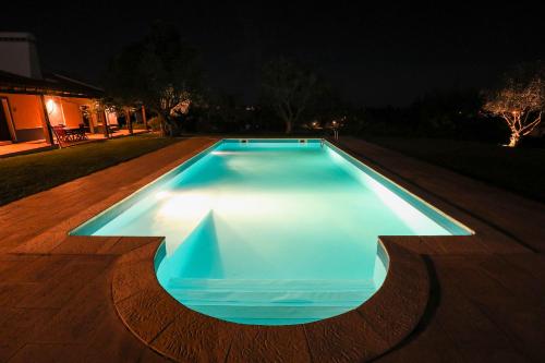 a swimming pool lit up at night at Quinta da Tapada de São Pedro in Vimieiro