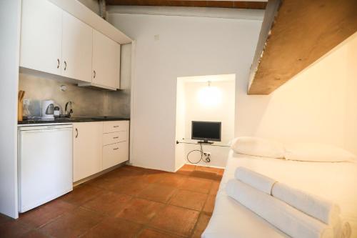 a kitchen with white cabinets and a couch in a room at Quinta da Tapada de São Pedro in Vimieiro