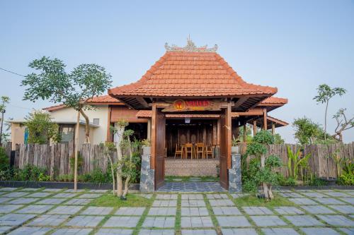 a building with a restaurant in front of a fence at Victory Munggu in Canggu