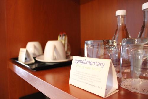 a table with glasses and a sign on it at Hotel Maluri in Kuala Lumpur