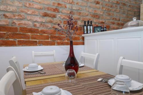 a dining room table with a red vase on it at Quinta da Tapada de São Pedro in Vimieiro