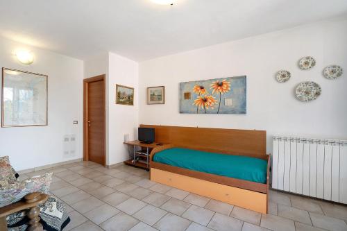 1 dormitorio con 1 cama y TV en la pared en Appartamento Matilde, en  Monvalle 