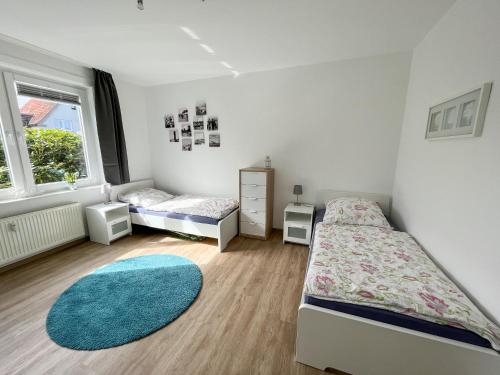 クックスハーフェンにあるAppartementhaus Nige Ooge Ferienwohnung Nr. 1のベッドルーム1室(ベッド2台、窓付)