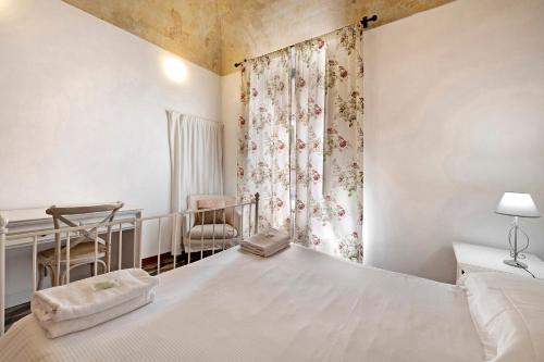a bedroom with a bed and a window with a crib at Bilocale Merlino in Finale Ligure