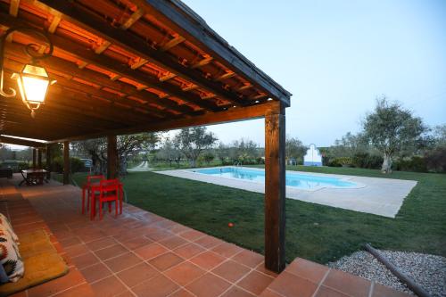 a patio with awning and a swimming pool at Quinta da Tapada de São Pedro in Vimieiro