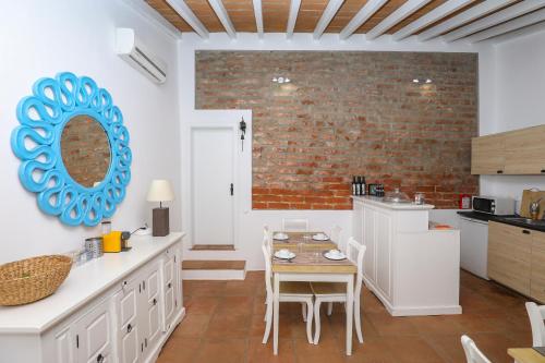 a kitchen with a table and a brick wall at Quinta da Tapada de São Pedro in Vimieiro