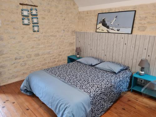 a bedroom with a bed and two blue tables at Gite de la Cour Vautier in Mandeville-en-Bessin