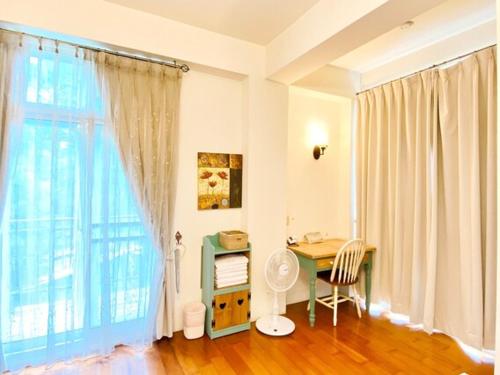 a room with a desk and a large window at Village Villa B&B in Zhuqi
