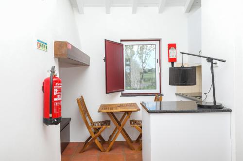 a room with a fire hydrant and a table at Quinta da Tapada de São Pedro in Vimieiro